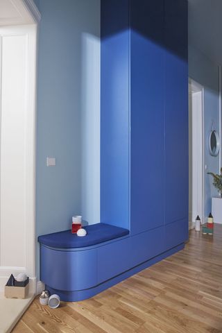 bright blue storage with a built in bench in a living room wall