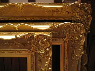 Top right hand corners of three ornate antique gold picture frames.