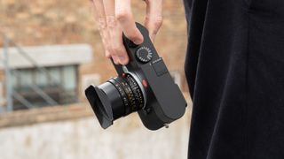 Leica M EV1 digital camera with lens attached, held in a person's hand