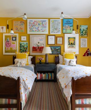 bedroom with bright yellow walls, twin beds, and eclectic decor with gallery wall