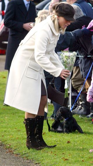 Zara Tindall holds a bunch of flowers handed to her by a child on Christmas Day 2003