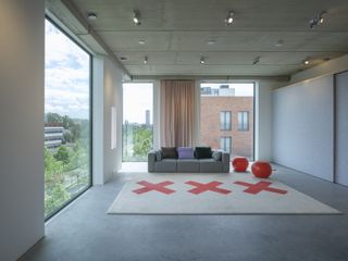 Seating area with city views and large cream rug with red crosses