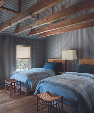 twin beds with blue bedding and gingham check wallpaper