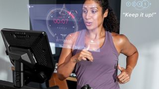An image showing a woman wearing a purple top running on the Bowflex Treadmill 10