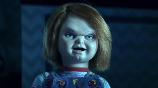 Chucky sneering while standing in the dark in Chucky Season 1