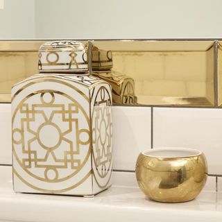bathroom with white and gold tiles and toiletries