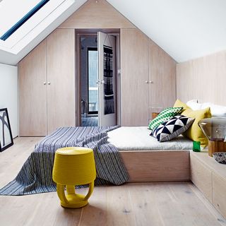 bedroom with yellow cushion and wooden floorboard