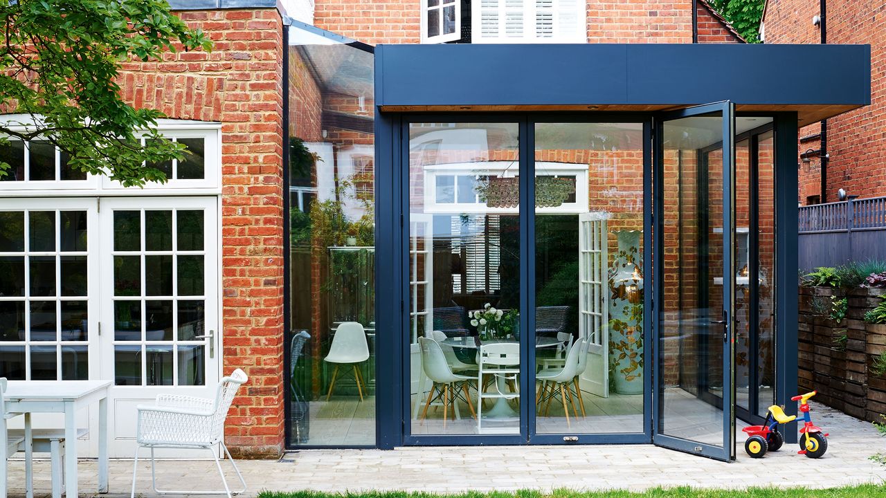 Exterior of brick home with modern black steel conservatory