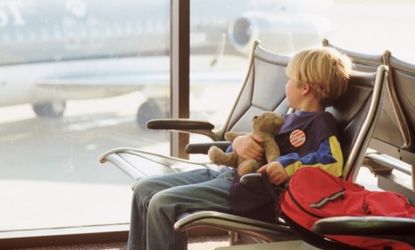 A child sits alone in an airplane terminal.