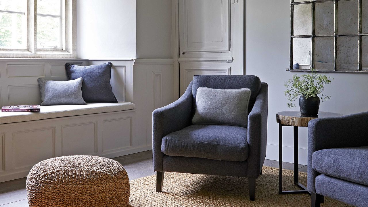 living room with blue armchairs, window seat and jute rug