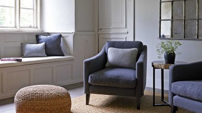 living room with blue armchairs, window seat and jute rug