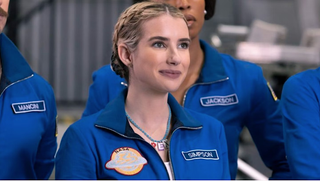 a young woman in a blue NASA filghtsuit