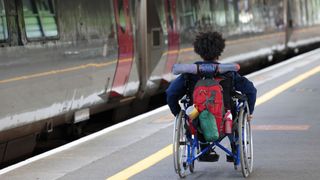 black friday railcard deals - man in wheelchair on a station platform with a train waiting - 1411369784