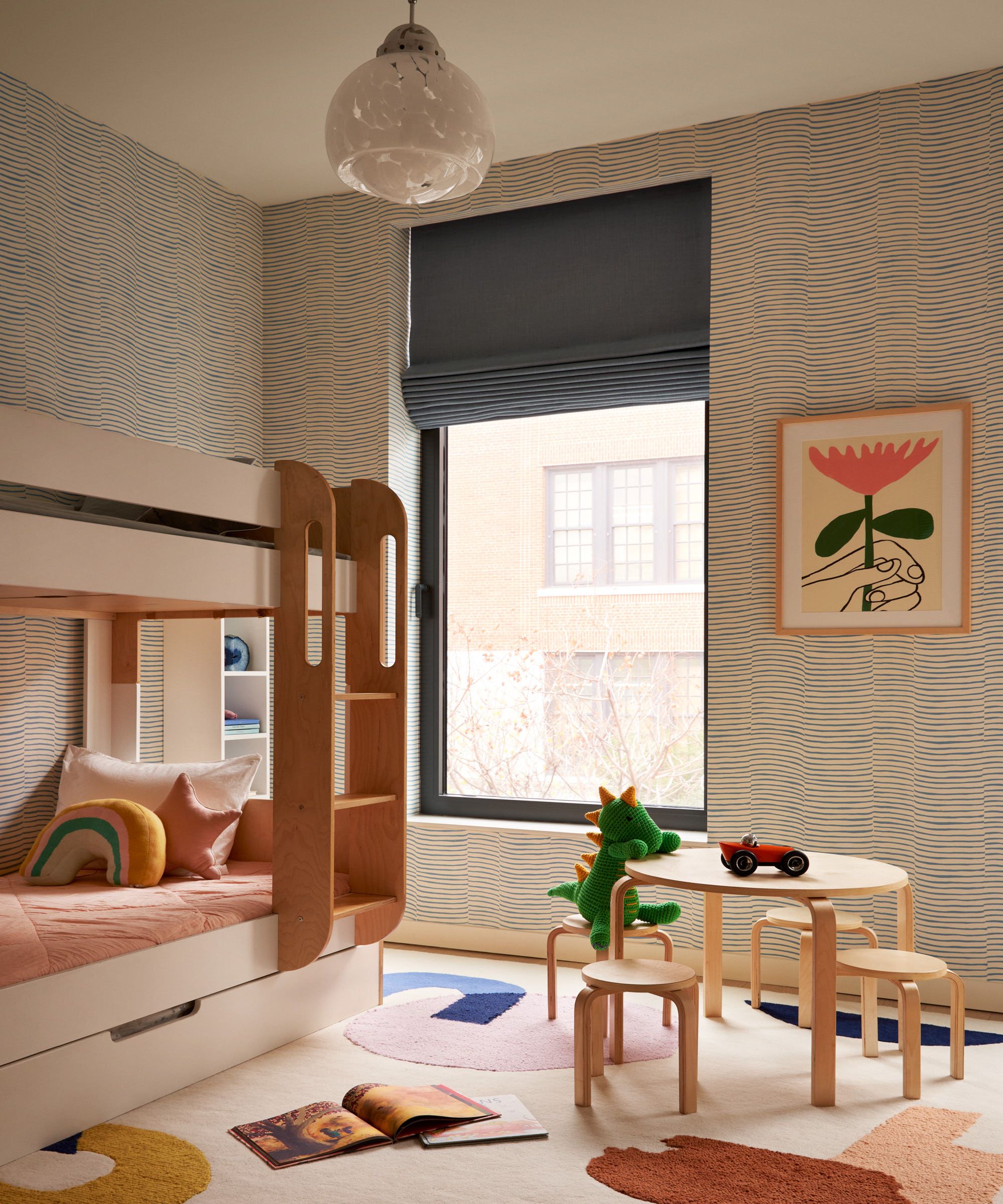 Kid's bedroom with bunk bed, abstract colourful rug, wood table and stools, printed wallpaper and art