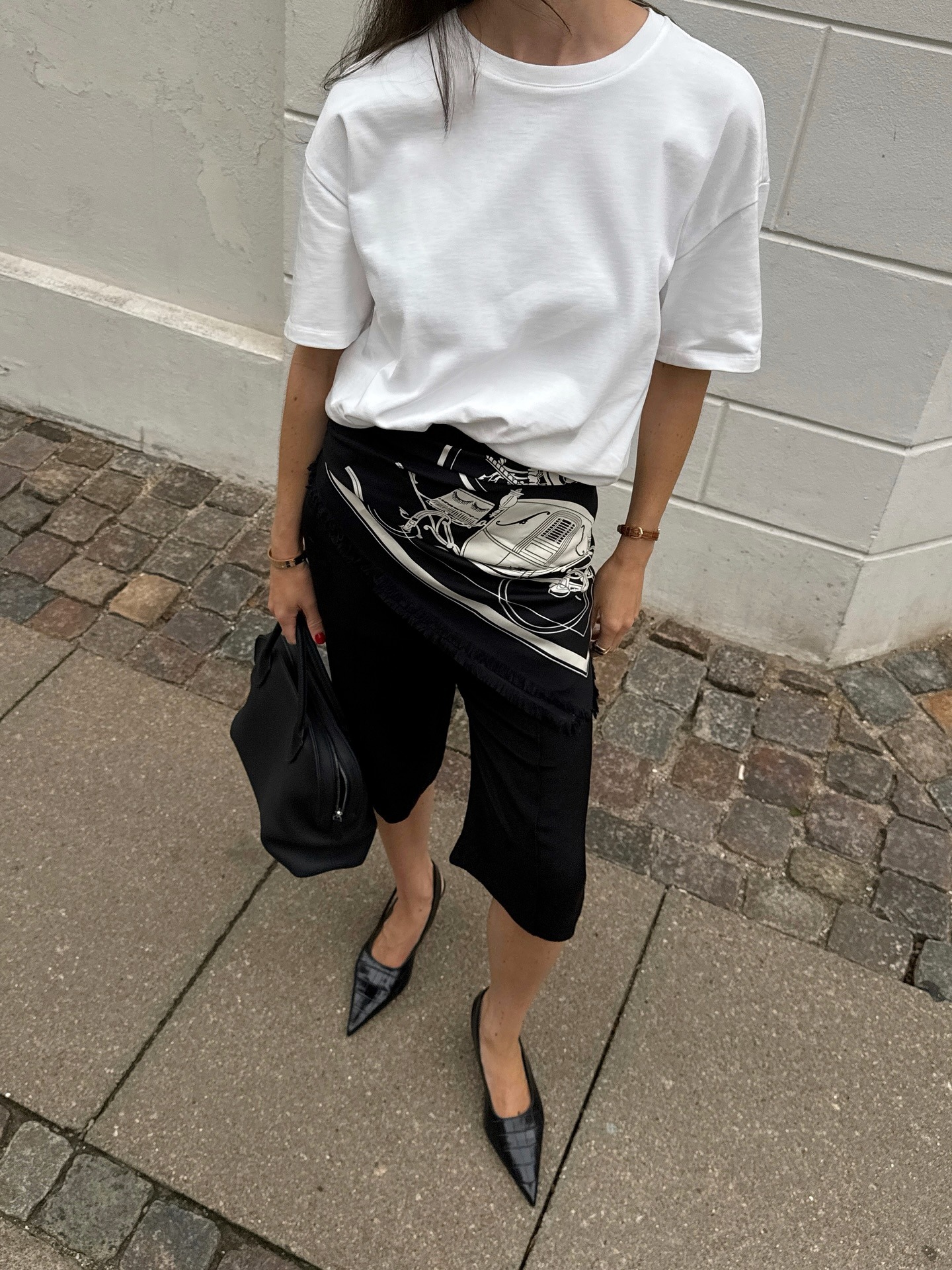 Woman in white t-shirt, capri pants, and pumps
