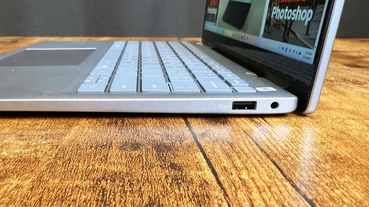 Close up of the right-side port array on the Dell 14 Plus 2-in-1 (Intel) laptop on a wooden desk, against a black backdrop.