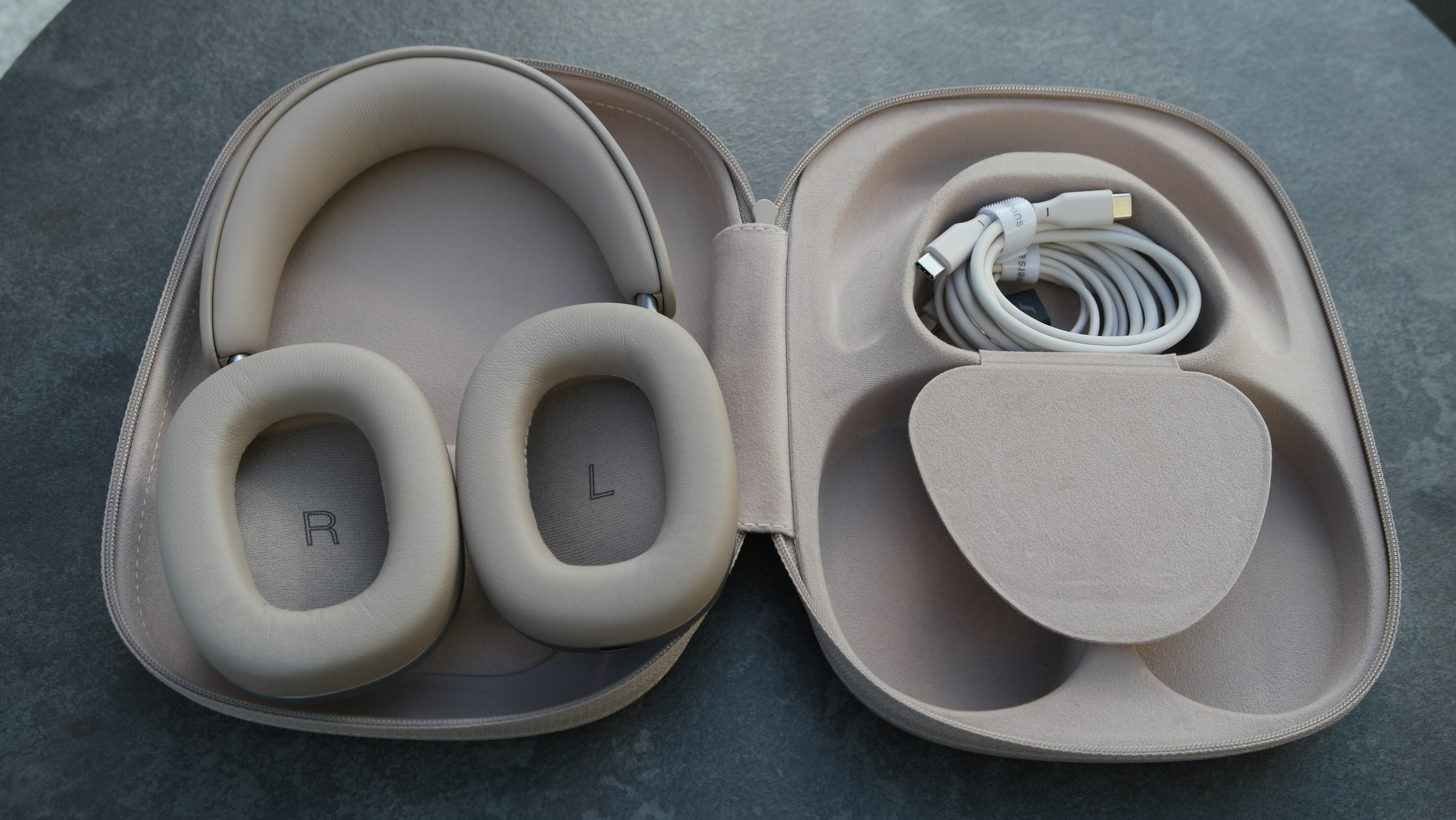 Bowers &amp; Wilkins Px8 S2 with the case open, and the storage pocket open, showing the cables inside.