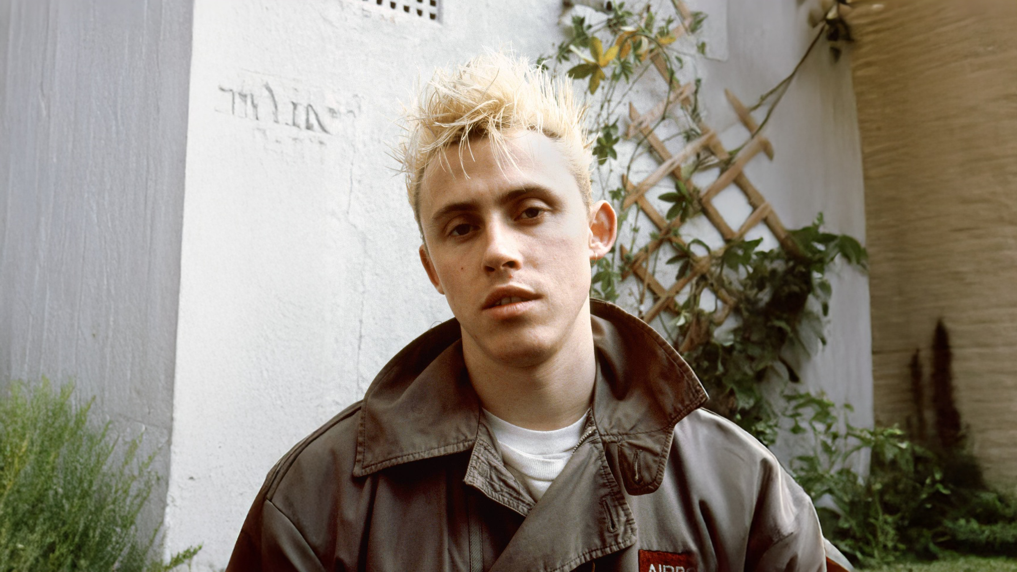 Kirk Brandon in 1980, posing in a garden wearing a camo jacket