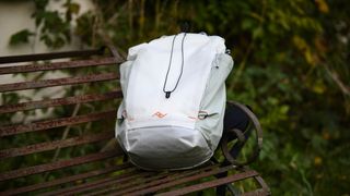 Peak Design Outdoor Backpack 25L in white, on a rustic bench