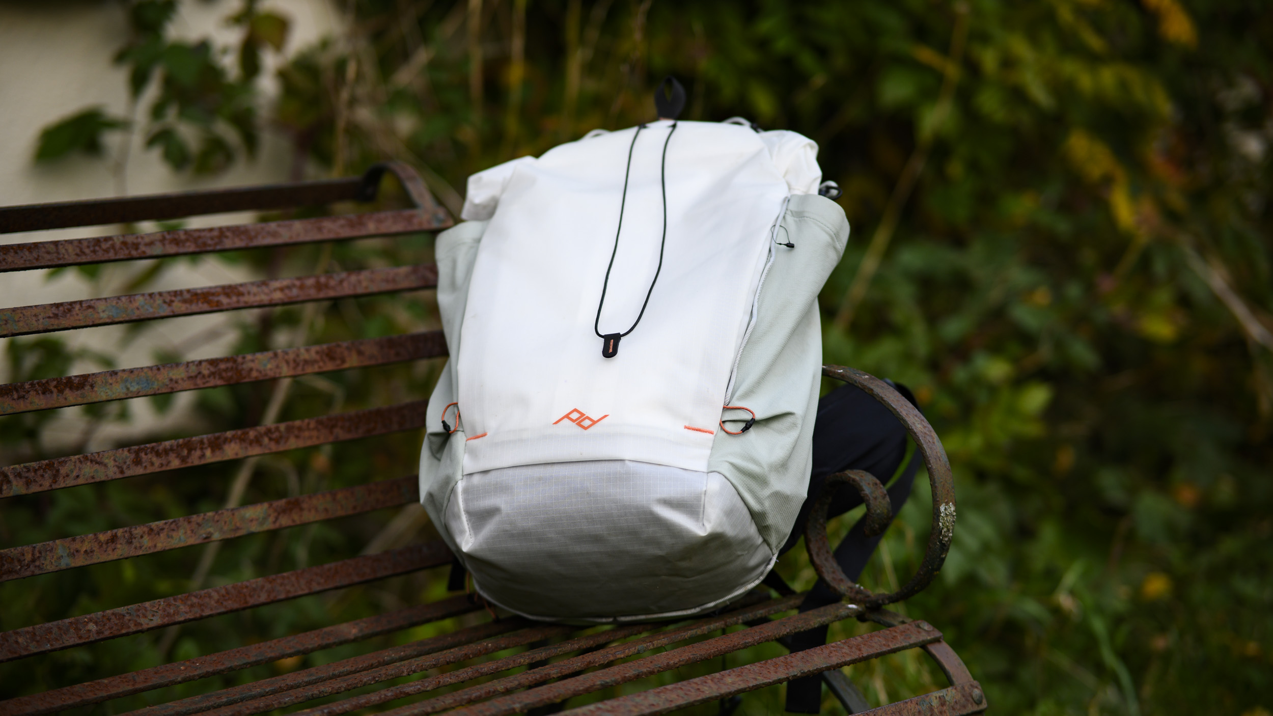 Peak Design Outdoor Backpack 25L in white, on a rustic bench