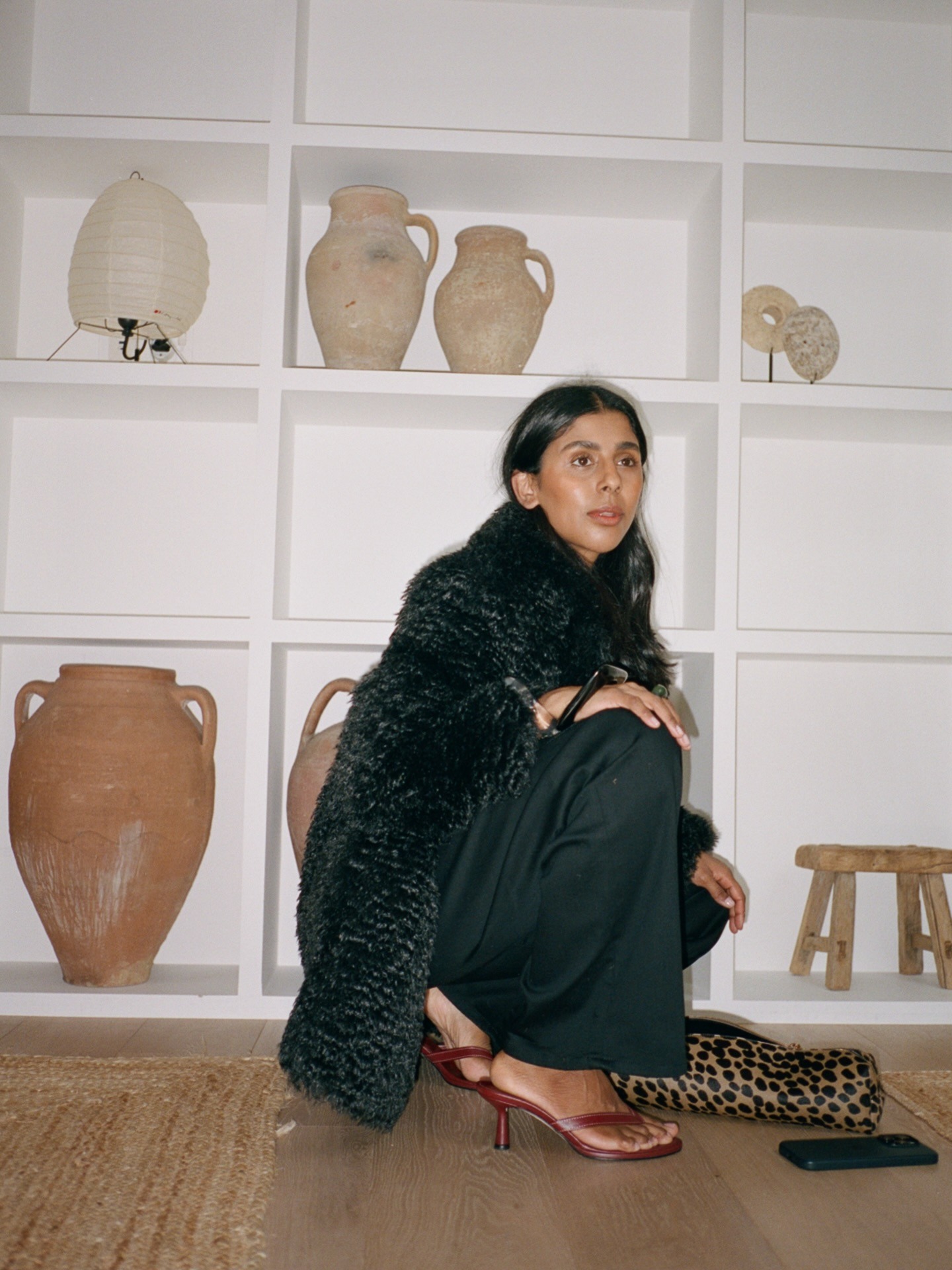 Woman in a black outfit with a leopard print bag