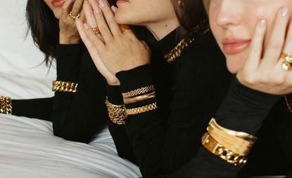 Models wear chunky gold jewellery by Anisa Sojka