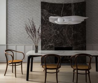 minimalist dining room with wood chairs and grey brick walls