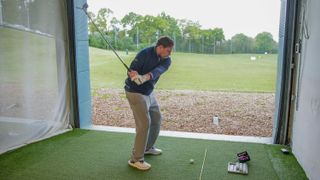 nick bonfield hitting a golf shot at a driving range