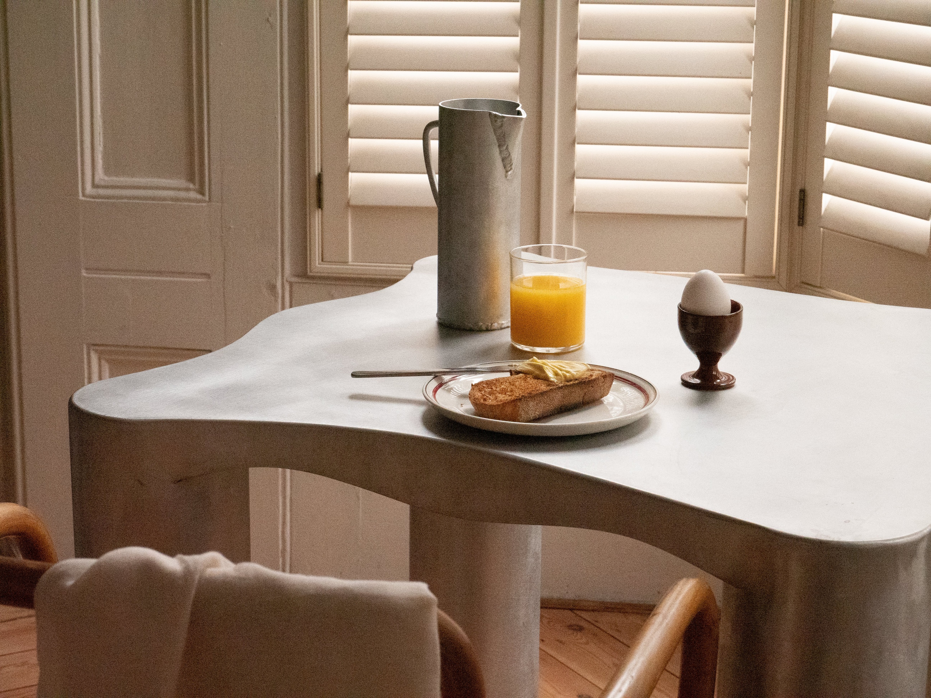 a silver curved dining table with a breakfast scene on it