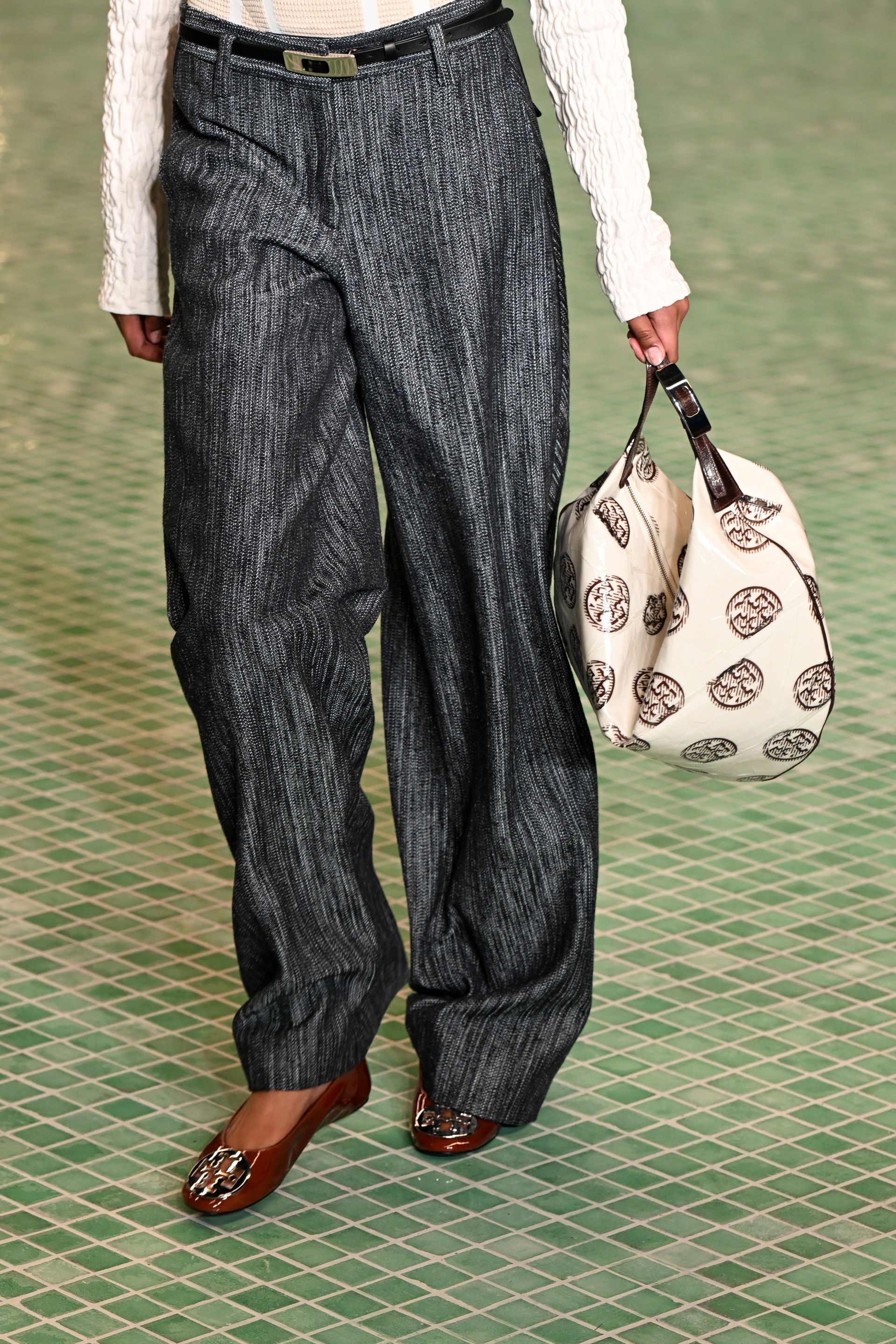 a model wears Tory Burch ballet flats on the runway with trousers