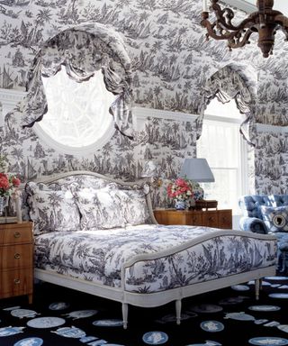 Bedroom decorated with black and white toile wallpaper, matched with the headboard and bedding