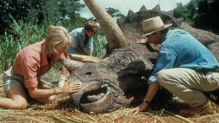 (L to R) Laura Dern as Ellie Sattler, Joseph Mazzello as Tim Murphy and Sam Neill as Alan Grant, tending to a Triceratops in Jurassic Park