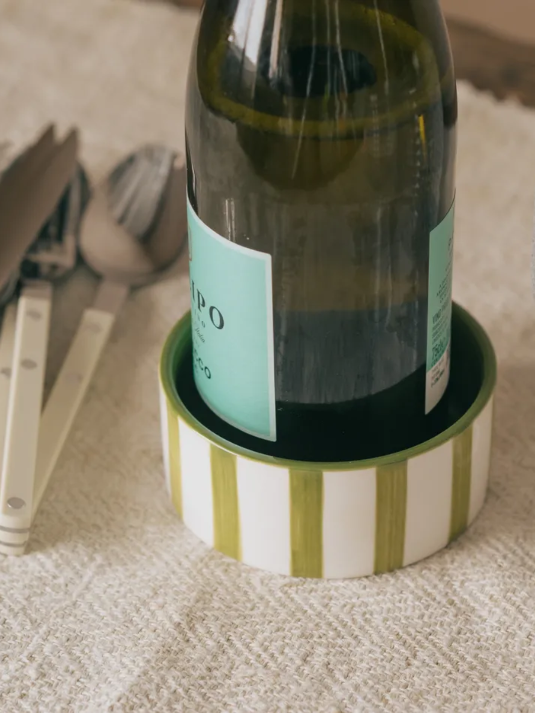 A striped white and green ceramic wine coaster from Graham &amp; Green