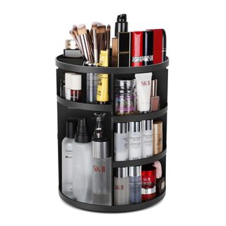 A black metal revolving cosmetics organizer filled with products