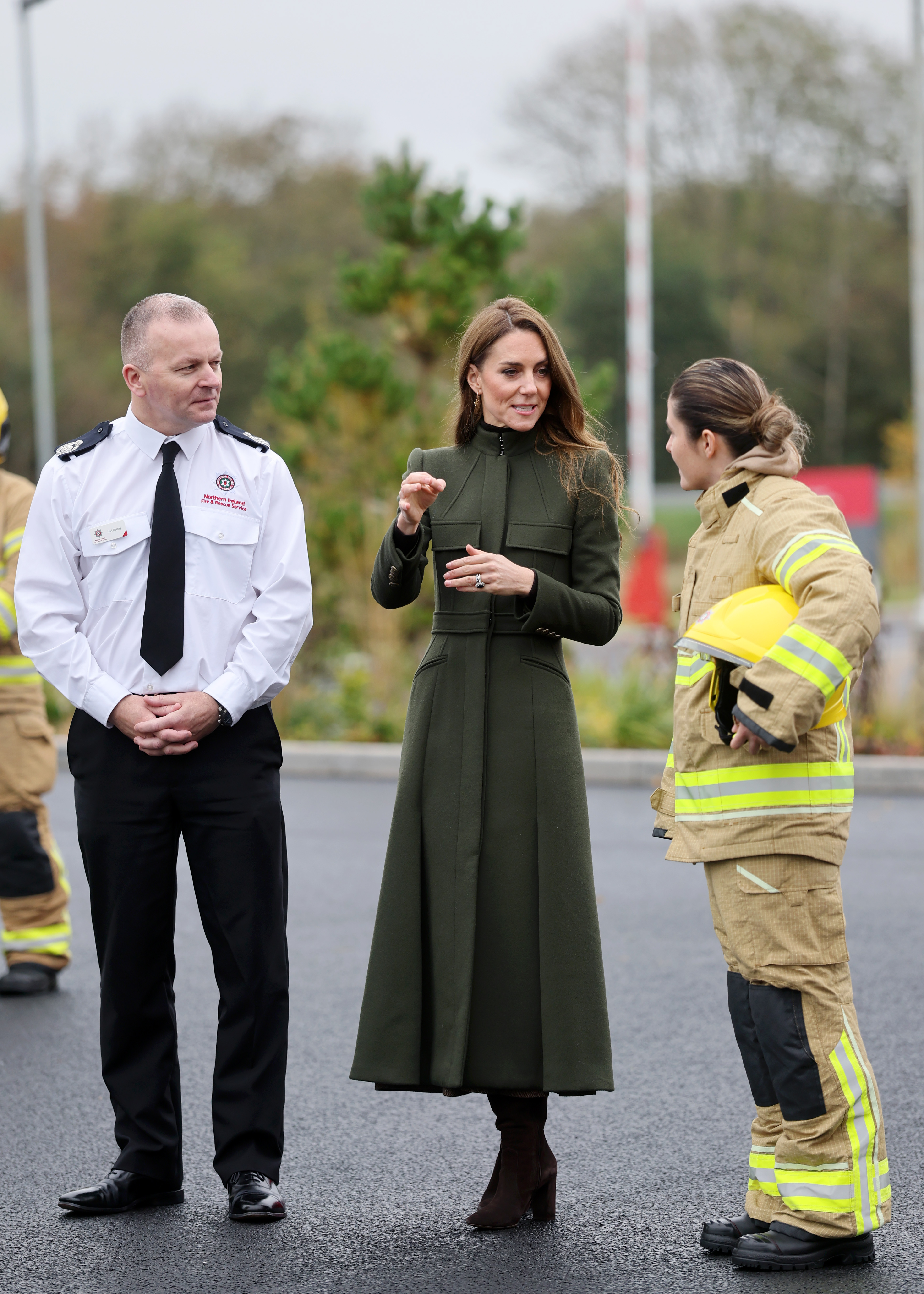 Kate Middleton wearing a green coat talking to firefighters