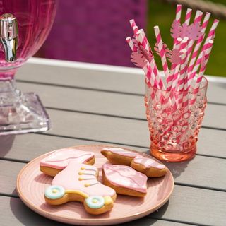 pink iced biscuits and straws on outdoor bar