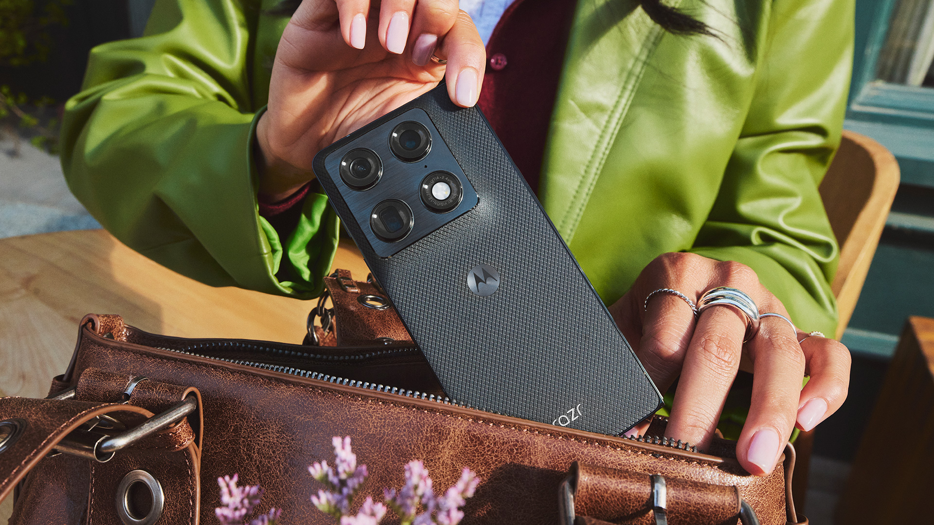 Woman pulling the Motorola Razr Fold out of her handbag