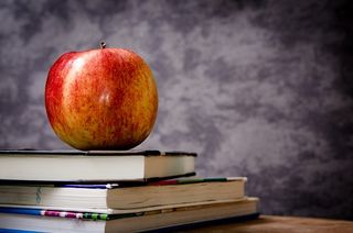 an apple on books in a classroom