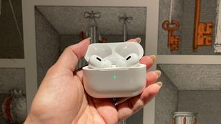 airpods in the case being held