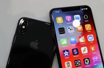 An iPhone XS on top of another gloss black iPhone XS