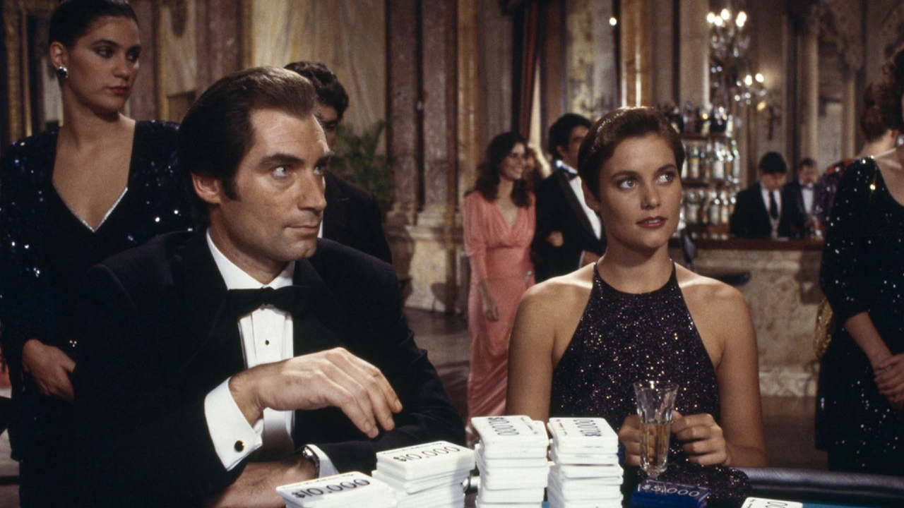 Timothy Dalton and Carey Lowell sit in front of stacks of betting plaques in Licence To Kill.