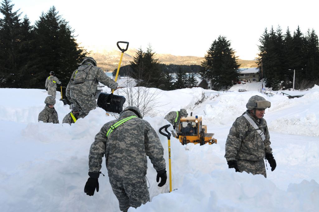 Alaska National Guardsmen clear a building roof in Cordova, near Anchorage, on Jan. 9. 