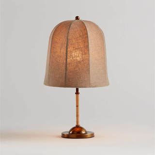 table lamp with linen-covered flared shade, rattan-wrapped stem, brass base