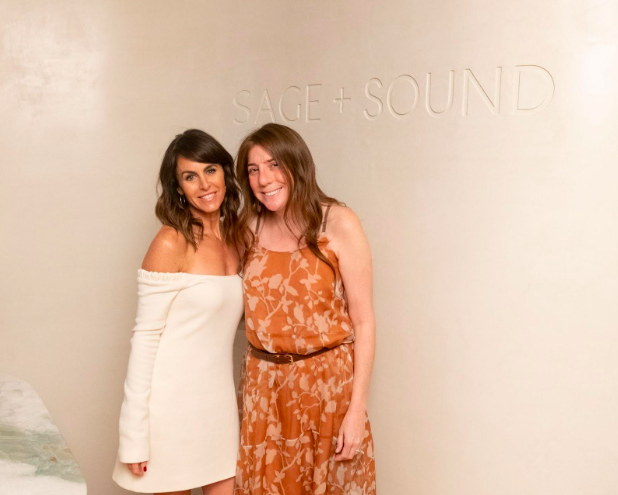 Two women in front of sign that says