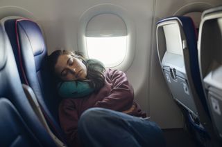 A woman asleep on a plane