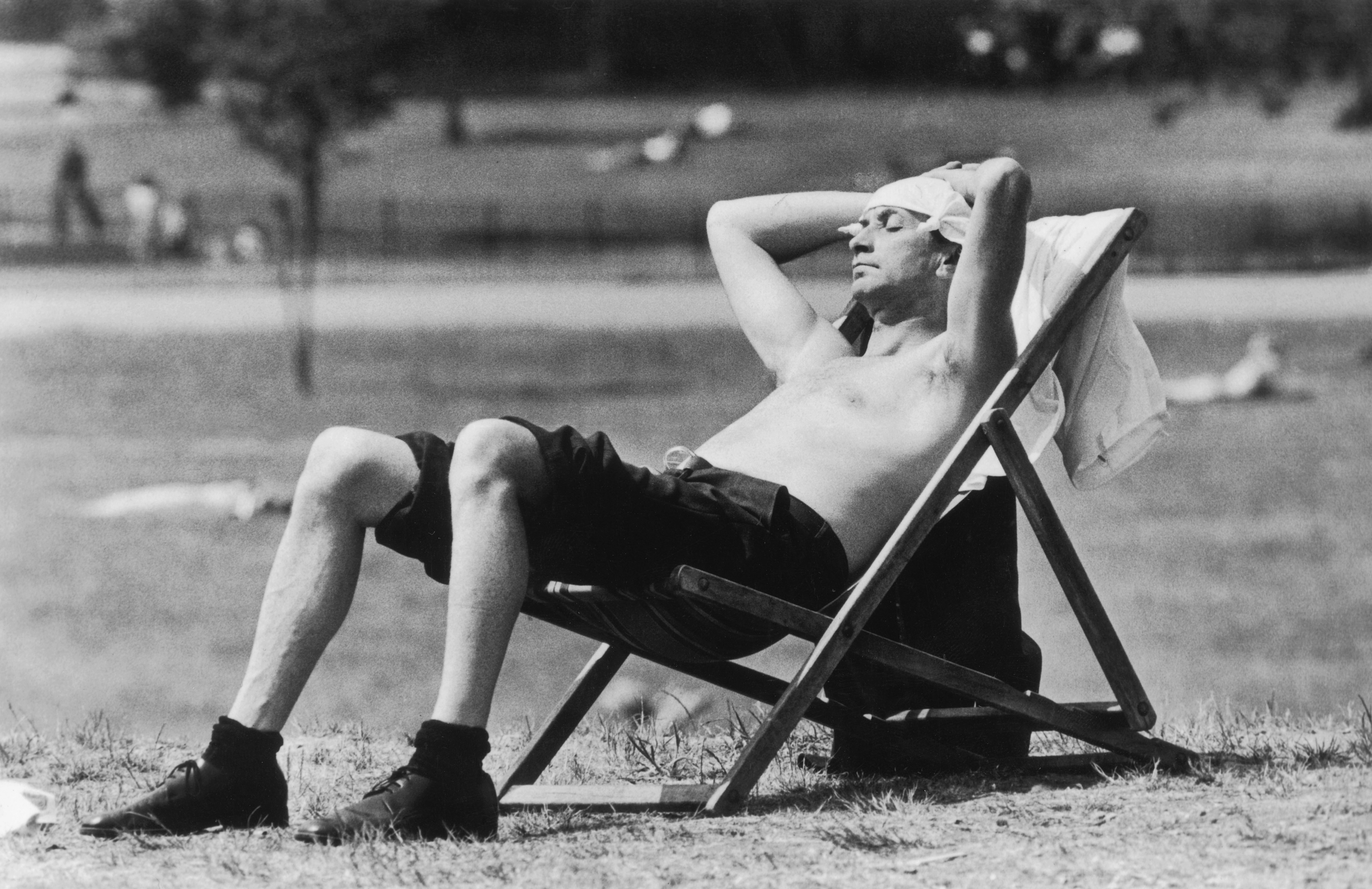  A Londoner sunbathing in Kensington Gardens during the heatwave in 1976 uses a knotted handkerchief to protect his head from the sun.