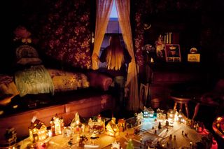 Photograph of a girl looking out of her window, with a toy town on a table in the foreground, by Bieke Depoorter, a member of the Magnum Photos agency