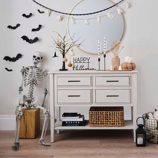 A hallway decked out in Halloween decorations, including a skeleton and bat bunting