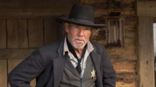 Dennis Quaid in Lawmen: Bass Reeves standing with his hands on his hips.