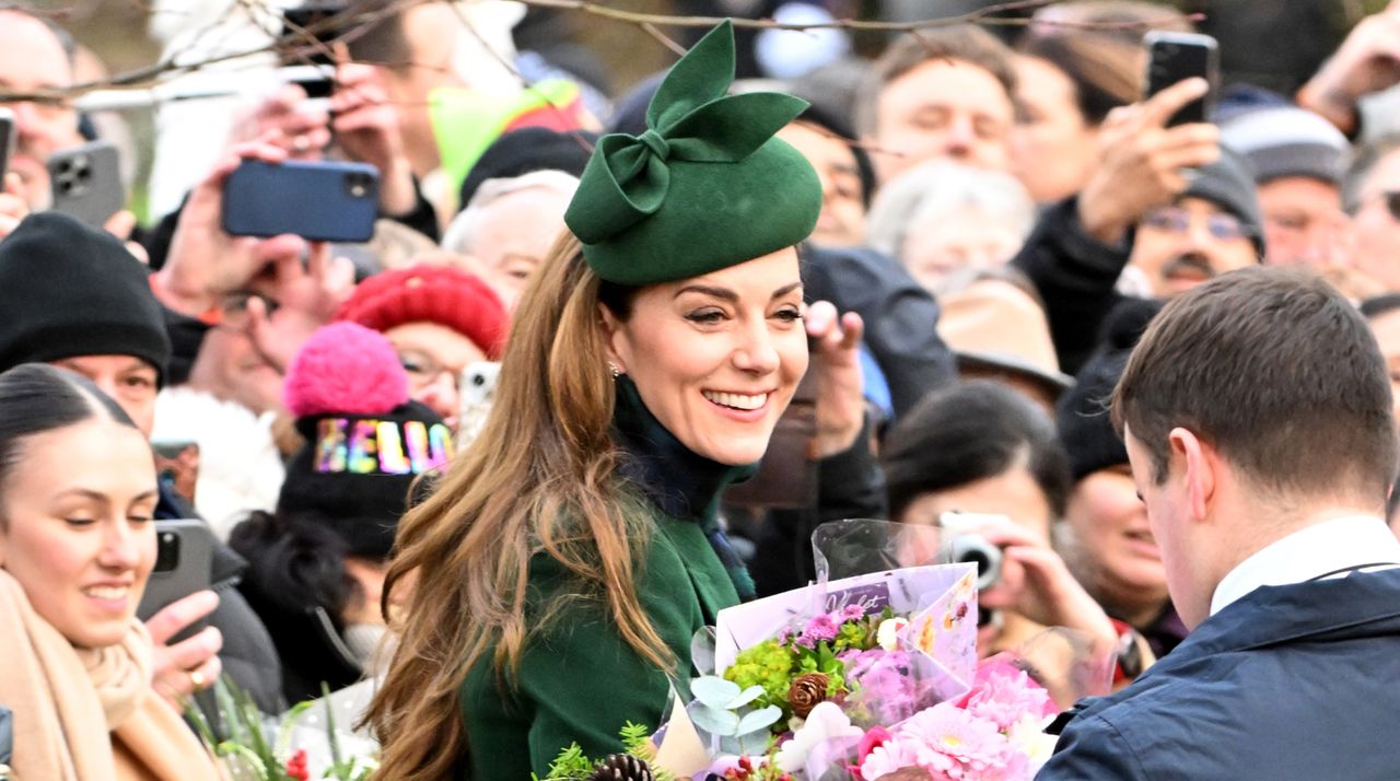 Kate Middleton wears a green hat and coat as she&#039;s surrounded by royal fans who have given her bunches of flowers at Sandringham